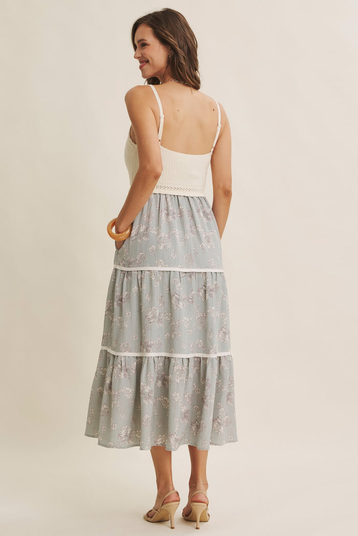 woman wearing a backless floral tiered maxi dress with a fitted bodice and spaghetti straps