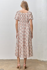 woman wearing a floral midi dress with short sleeves and a gathered waist, seen from the back