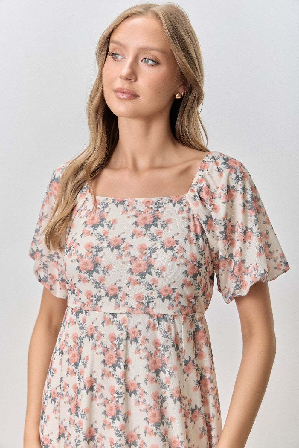 woman wearing a floral print short sleeve dress with a square neckline and soft, flowing fabric