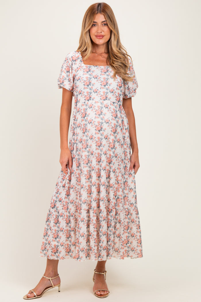 woman wearing a floral maternity maxi dress with short sleeves and a square neckline, showcasing her baby bump