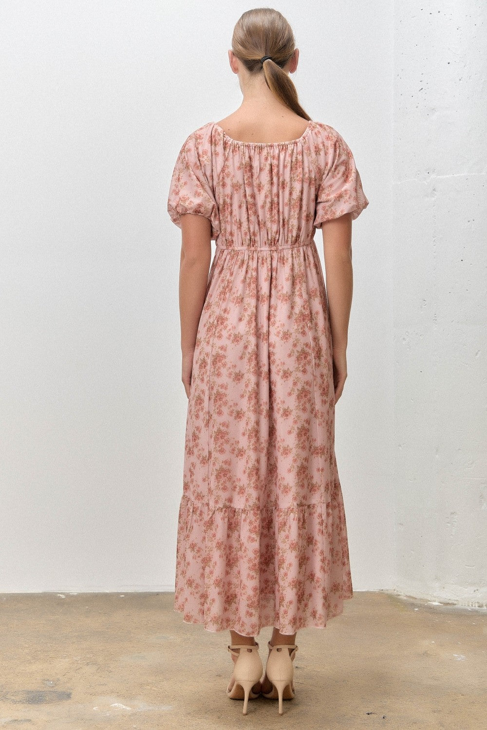 woman wearing a pink floral maxi dress with puff sleeves and a smocked back detail