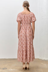 woman wearing a pink floral maxi dress with puff sleeves and a smocked back detail
