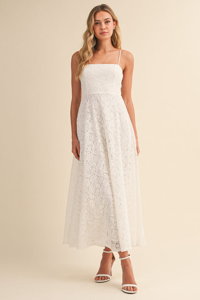 woman wearing a white lace maxi dress with spaghetti straps and a fitted bodice