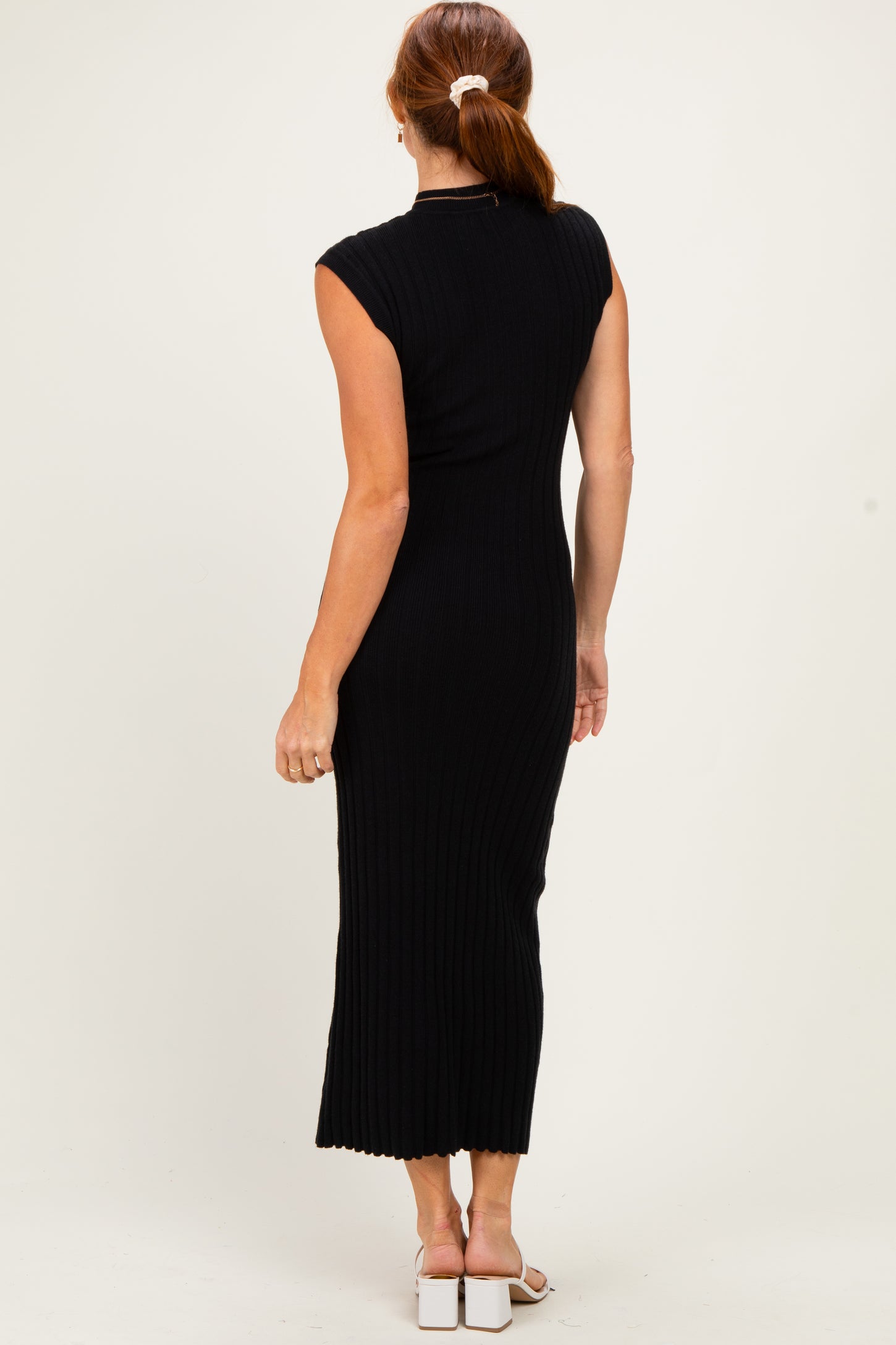 woman wearing a fitted black ribbed maxi dress with cap sleeves and a back view, showcasing a sleek silhouette
