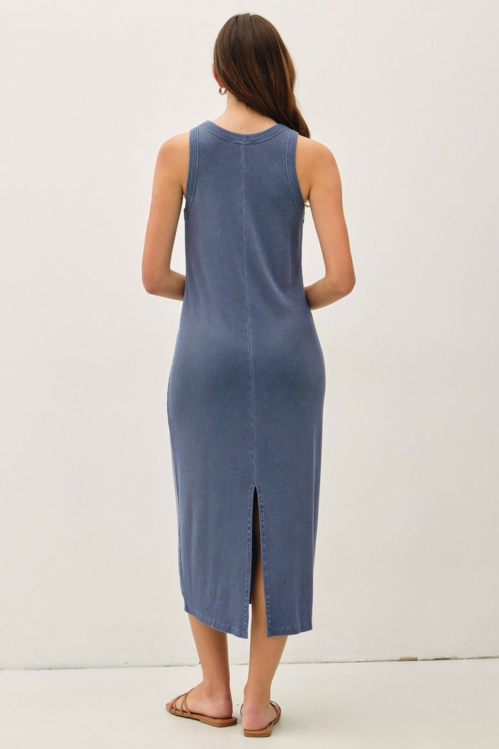 woman wearing a blue sleeveless midi dress with a back slit and a relaxed fit