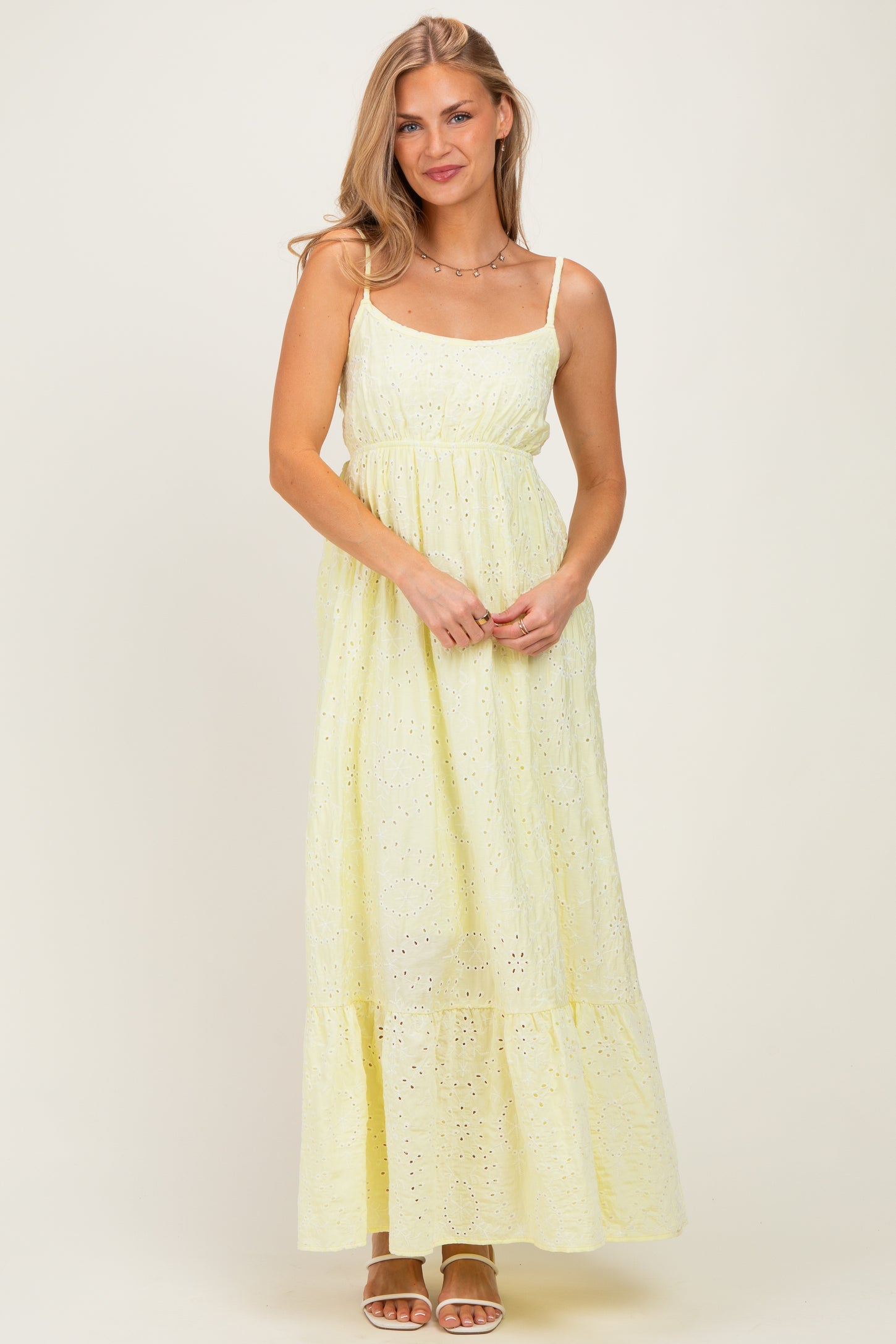 woman wearing a light yellow maxi dress with a tiered bottom and lace detailing