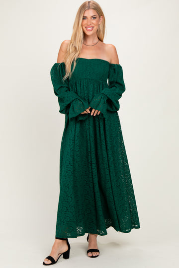 woman wearing a dark green off-the-shoulder lace maxi dress with long bell sleeves and a flowy skirt
