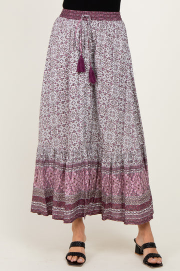 woman wearing a purple and white patterned maxi skirt with tassel drawstring and layered hemline