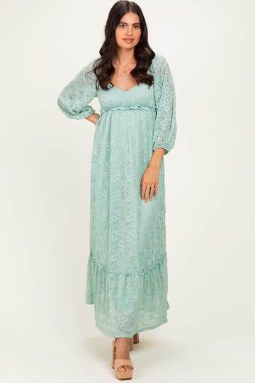 woman wearing a light mint green maxi dress with puff sleeves and a ruffled hem