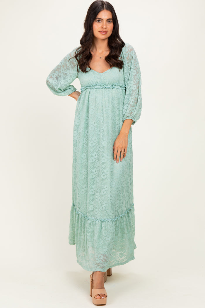 woman wearing a light mint green maxi dress with puff sleeves and a ruffled hem