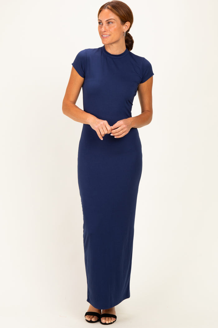 woman wearing a navy blue cap sleeve maxi dress standing with hands clasped at the waist