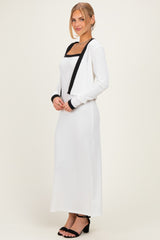 woman wearing a white long sleeve maxi dress with black accents and a square neckline