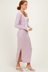 woman wearing a light lavender long sleeve maxi dress with side slits and white trim details