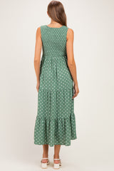 woman wearing a green polka dot maternity maxi dress with smocked bodice and tiered skirt, showing her back
