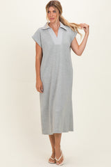 woman wearing a gray midi dress with a collared neckline and short sleeves, styled casually with sandals