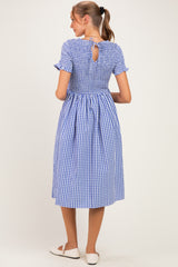 woman wearing a blue and white gingham maternity dress with short sleeves and a keyhole back detail