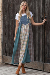 woman wearing a denim patchwork maxi dress with plaid and solid panels, paired with brown ankle boots