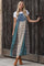 woman wearing a denim patchwork maxi dress with plaid and solid panels, paired with brown ankle boots