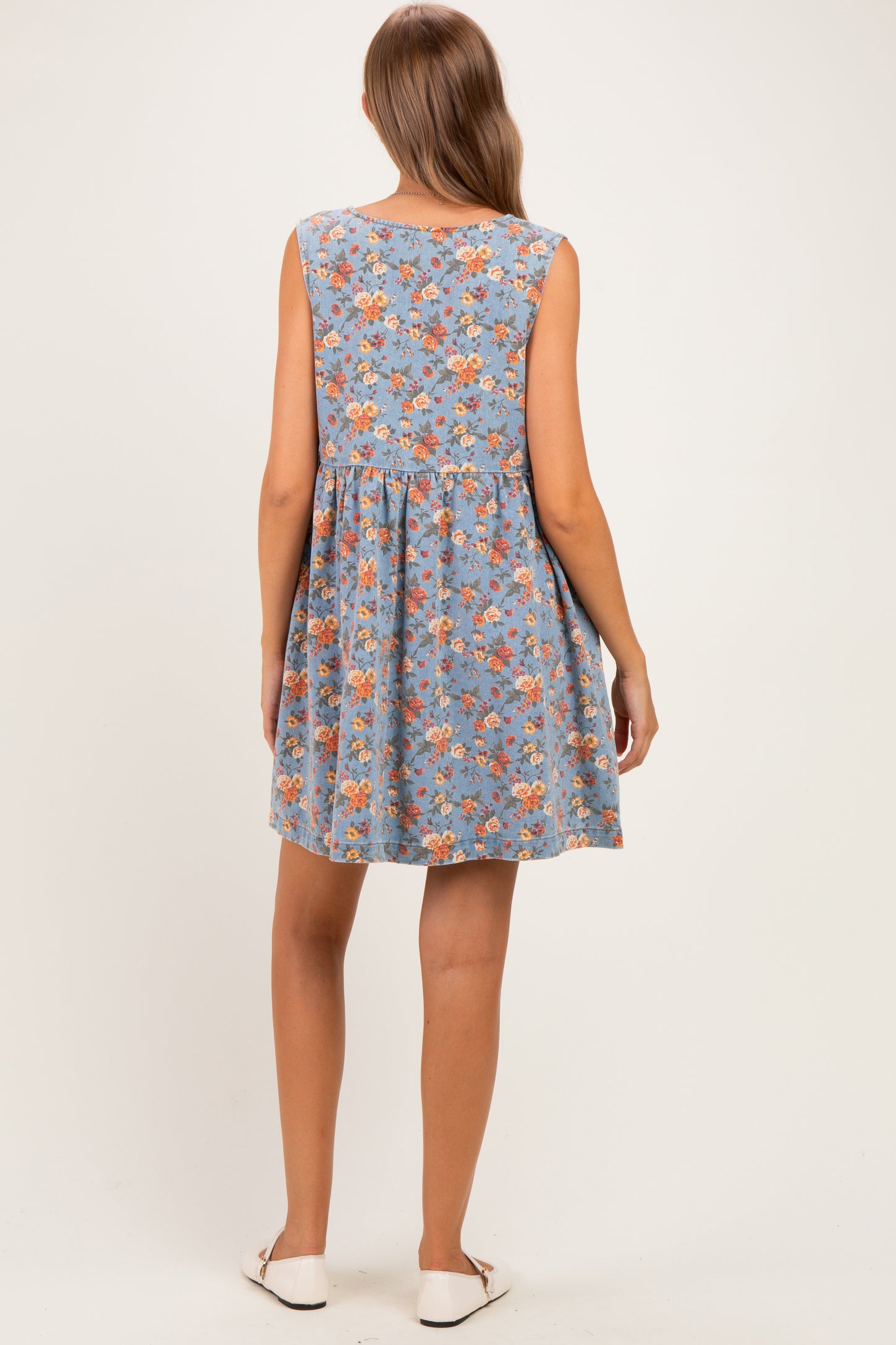 woman wearing a blue floral sleeveless maternity dress with a flared skirt