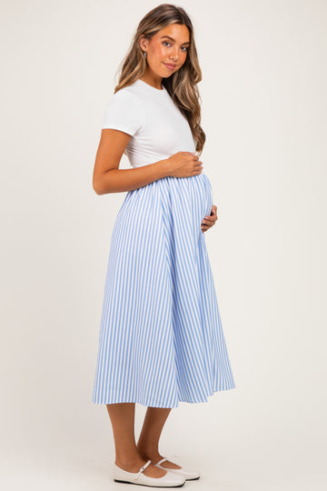 woman wearing a white short sleeve top and a blue and white striped maternity skirt, holding her baby bump