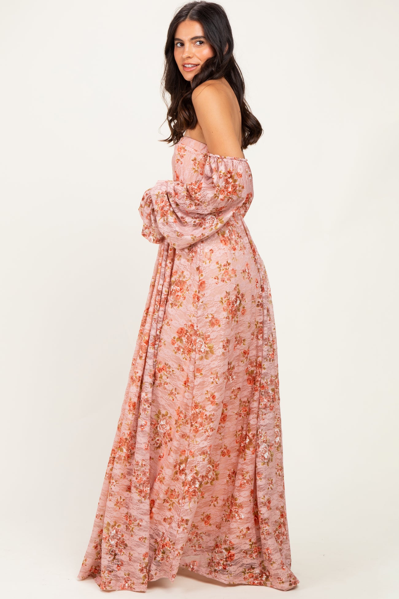 woman wearing a blush pink off-the-shoulder floral maxi dress with long puff sleeves