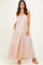 woman wearing a blush pink maxi dress with navy polka dots and pockets, styled with beige platform heels