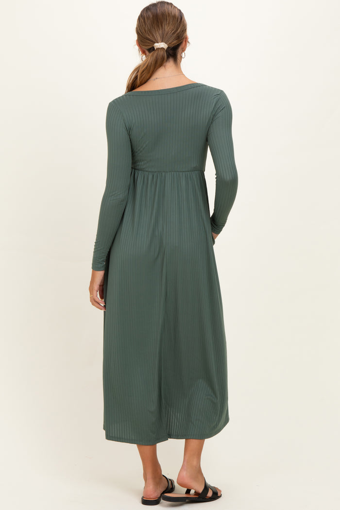 woman wearing a dark green long sleeve maternity dress with a textured ribbed design, shown from the back