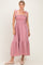 woman wearing a pink and white gingham maxi dress with tie straps and ruffled hem