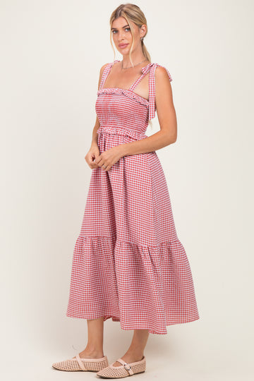 woman wearing a red and white gingham maxi dress with tie straps and a tiered skirt