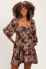 woman wearing a brown floral maternity dress with puff sleeves and a visible baby bump
