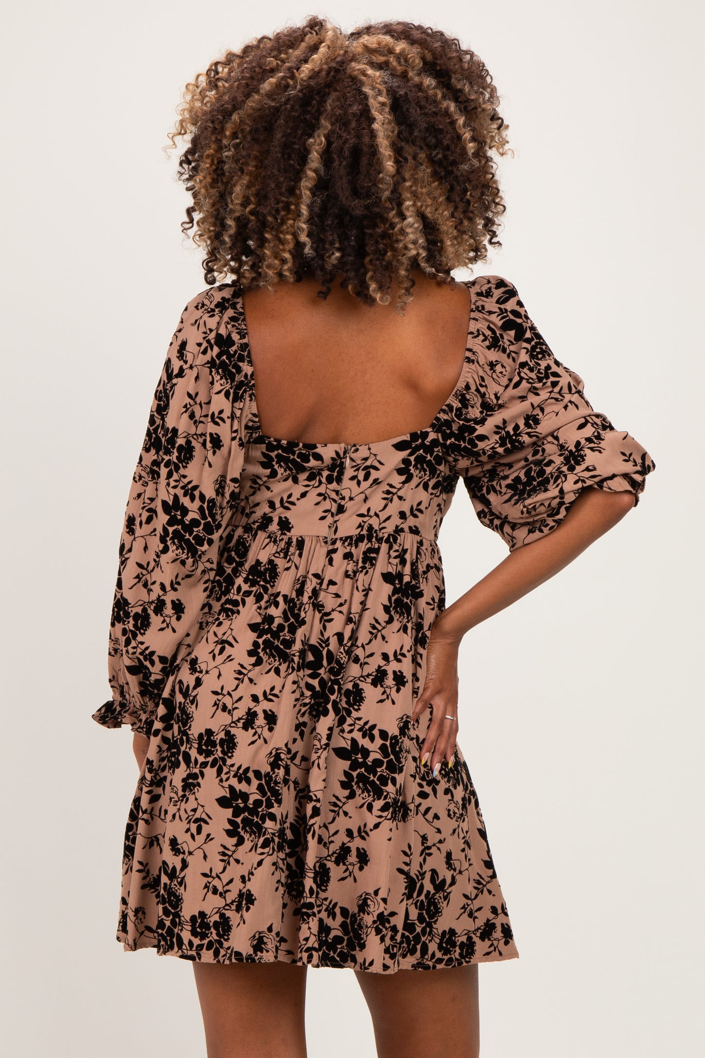 woman wearing a floral print maternity dress with puff sleeves and a square back design
