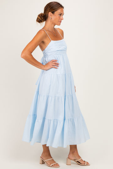 woman wearing a light blue tiered maxi dress with spaghetti straps and a fitted bodice