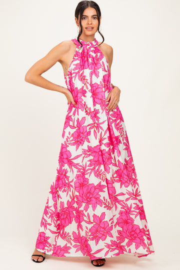woman wearing a halter neck pink floral maxi dress with a flowy silhouette