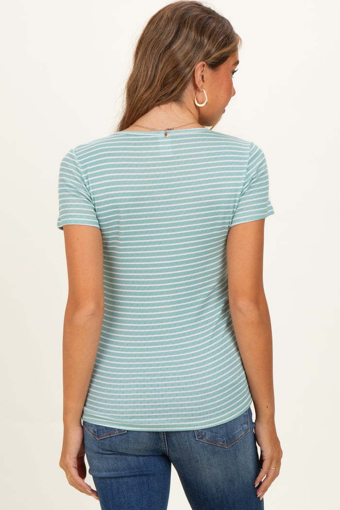 woman wearing a striped light teal maternity top, viewed from the back, paired with blue jeans