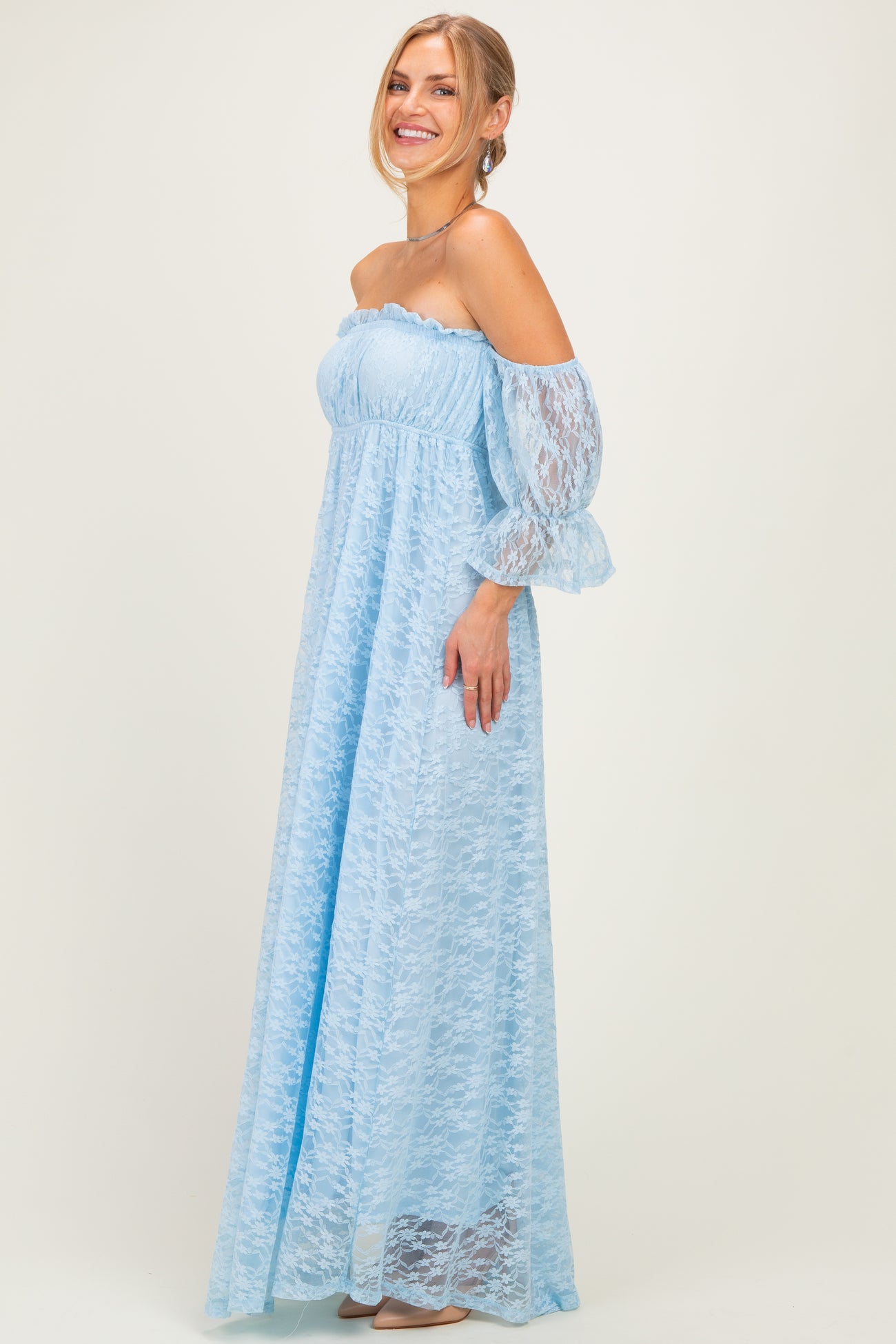 woman wearing a light blue off-the-shoulder maxi dress with lace details and long puff sleeves