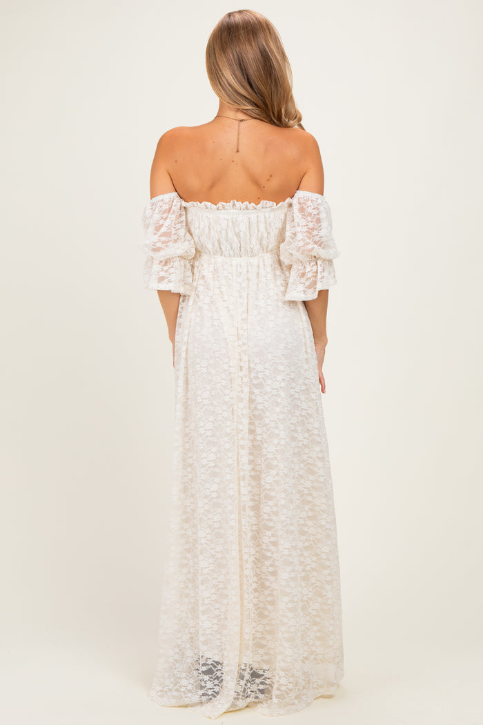 woman wearing a white off-the-shoulder maxi dress with puff sleeves and a floral lace design, viewed from the back