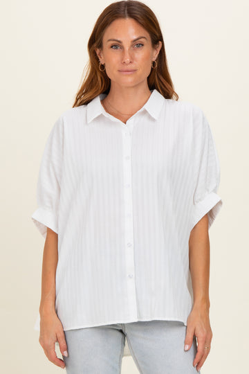 woman wearing a white short sleeve button-up blouse with a relaxed fit and subtle stripe detail