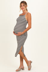 woman wearing a striped maternity dress with a side slit and holding her baby bump