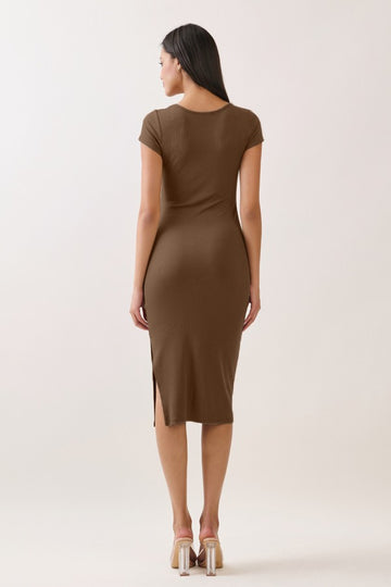 woman wearing a fitted brown midi dress with short sleeves and a side slit