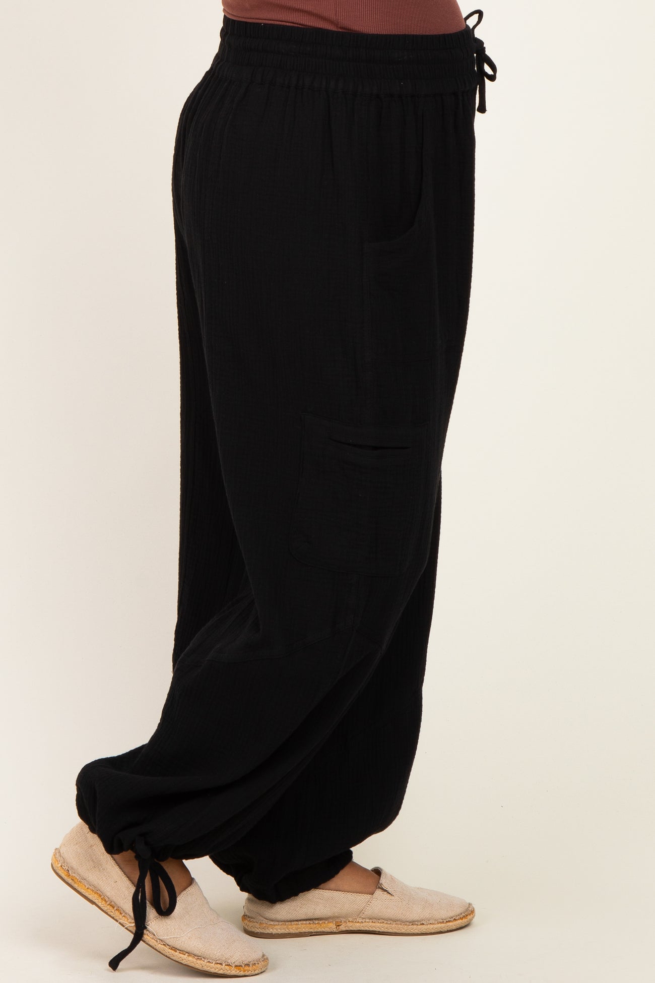 woman wearing black maternity wide-leg pants with pockets and a drawstring waist, side view