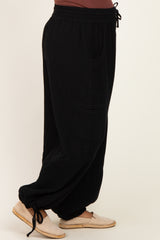 woman wearing black maternity wide-leg pants with pockets and a drawstring waist, side view