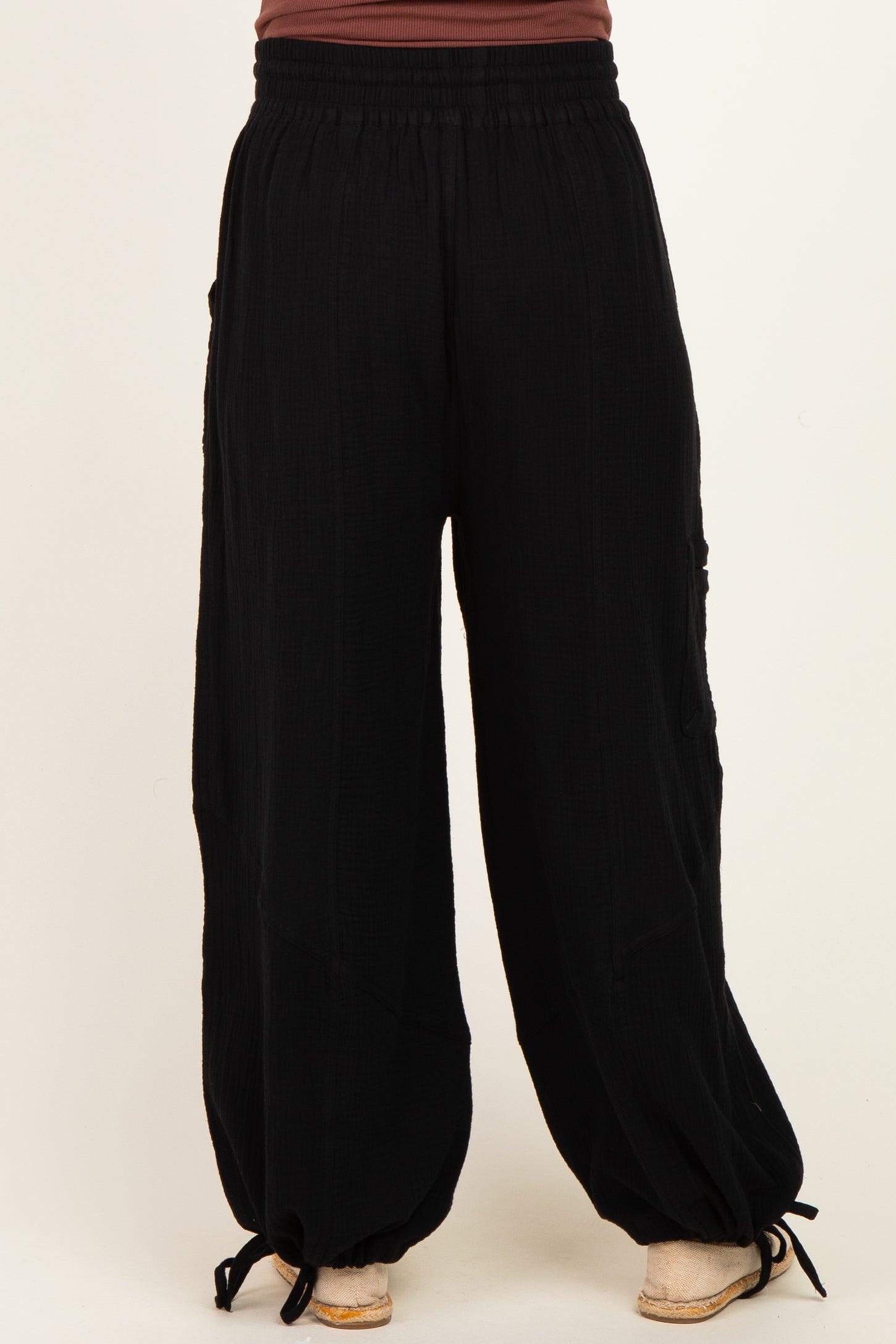 woman wearing black maternity wide-leg pants with a relaxed fit and drawstring detail at the ankles