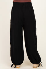 woman wearing black maternity wide-leg pants with a relaxed fit and drawstring detail at the ankles