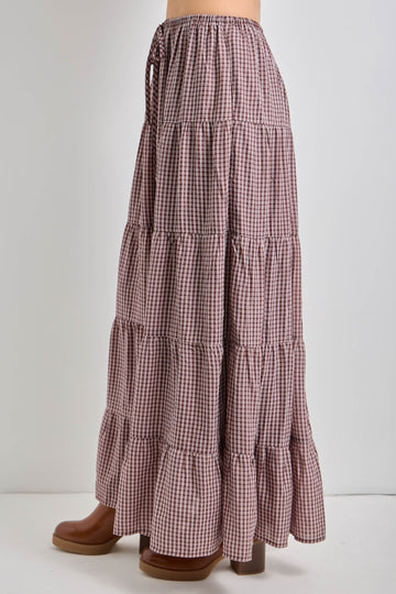 long tiered maxi skirt in a brown and white gingham pattern with an elastic waistband and side ties