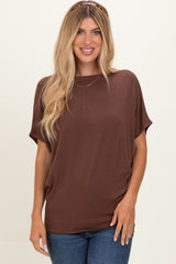 woman wearing a brown short sleeve top with a relaxed fit and denim jeans