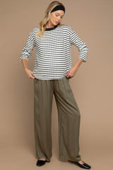woman wearing a striped maternity top with long sleeves and loose olive green maternity pants