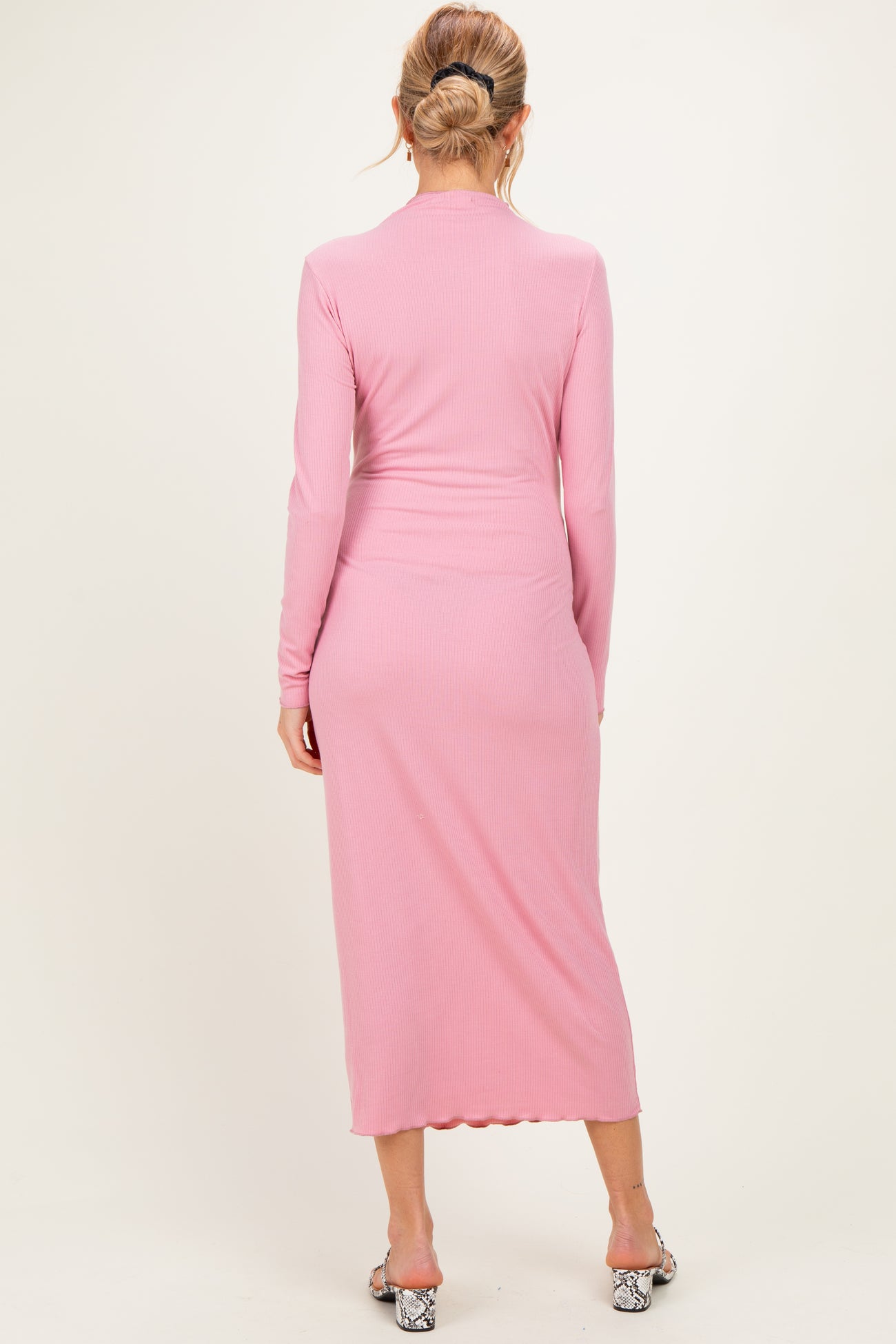 woman wearing a light pink long sleeve maternity dress with a fitted silhouette and back seam detailing