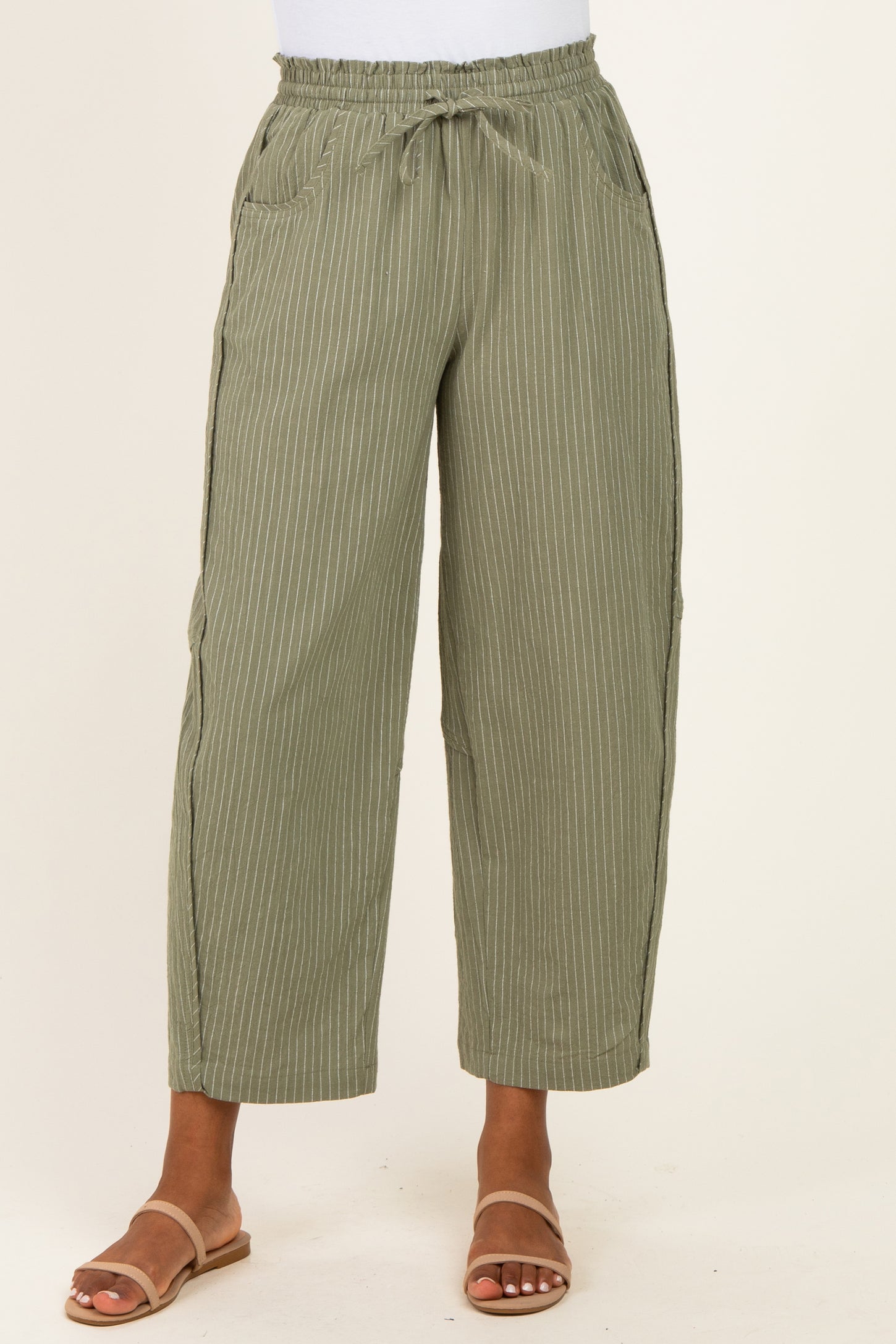 women wearing olive green striped wide-leg pants with an elastic waistband and pockets