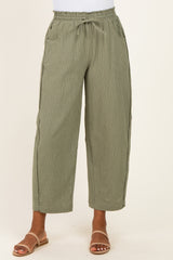 women wearing olive green striped wide-leg pants with an elastic waistband and pockets