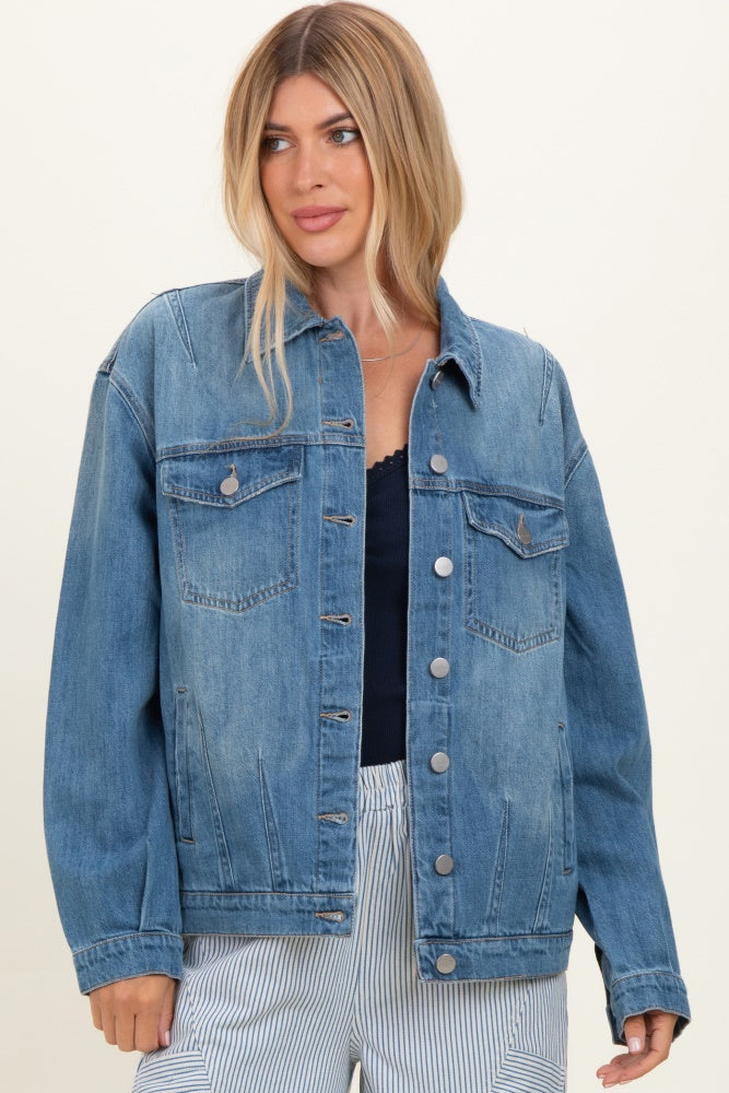 woman wearing a light wash denim jacket with front pockets and button closure, styled with a navy top and striped pants